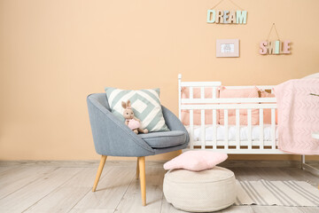 Interior of nursery with crib, armchair and pouf