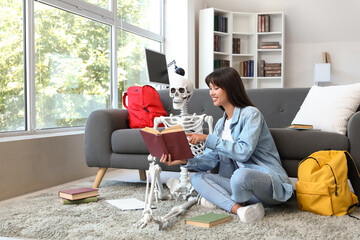 Female student with human skeleton model reading book at university