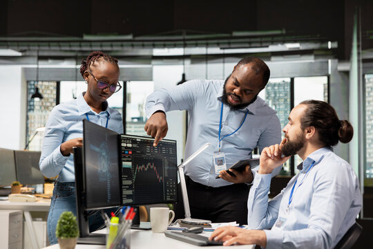 Team of day traders brainstorming in office, doing strategy to capitalize on market fluctuations. Teamworking proprietary firm colleagues analyzing stock exchange price movements for fast profit