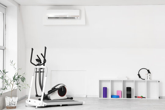 Interior of gym with sports equipment and shelf unit
