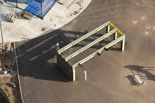 Outdoor fitness playground equipment with climbing wall and monkey bars, aerial view