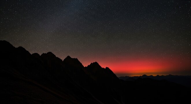 Starry night sky over mountain silhouette with vibrant sunset horizon - Powered by Adobe