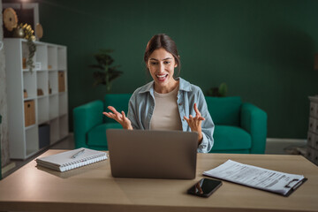 Businesswoman having video call and gesturing during online meeting at home