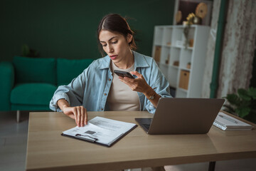 Freelancer scanning document with smart phone in home office