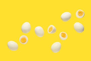 Flying many boiled chicken eggs on yellow background