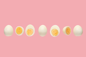 Flying boiled chicken eggs on pink background