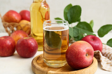 Glass and bottle of fresh apple cider with fruits on white background
