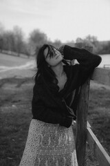 a very natural and elegant woman poses for a photo against the backdrop of nature, dressed in light...