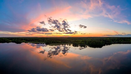 Fototapeta premium Panoramic sunset over a lake reflecting the clouds