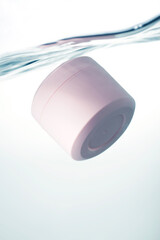 Pink cosmetic jar underwater