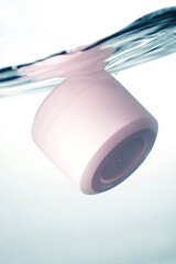 Pink cosmetic jar underwater
