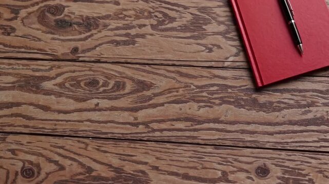 Red Notebook and Pen on Wooden Table Texture Background for Learning Concept with Copy Space