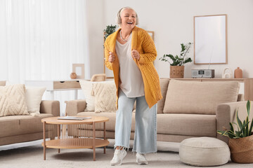 Senior woman in headphones listening to radio at home