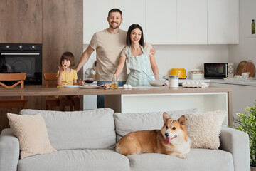 Happy family with Corgi dog making pancakes in kitchen