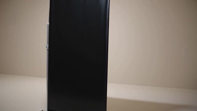 three-dimensional rendered representation of black retractable advertising banner positioned in studio environment featuring beige colored wall and flooring