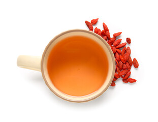 Cup of hot goji tea and berries on white background
