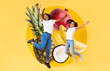 African American mouther and daughter leap in excitement against a bright yellow background,...