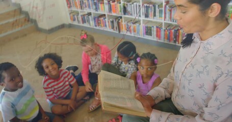 Teacher opening storybook and reading aloud in library engaging kids with animated letters