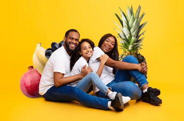 A joyful family poses together amidst a vibrant collage of fruits, emphasizing the importance of...