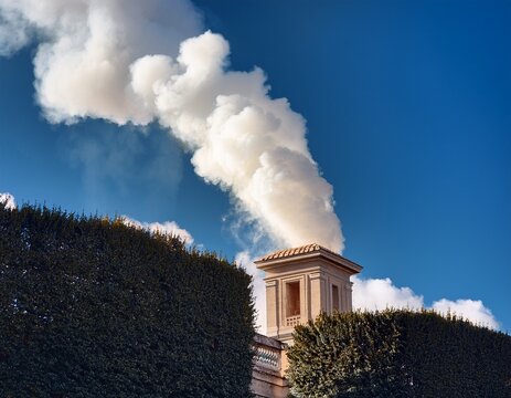 white smoke rises from the chapel chimney in vatican city symbolizing the election of a new pope by the conclave