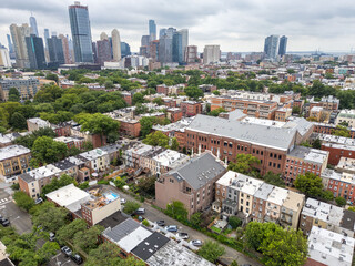An urban landscape with low rise and high rise buildings on a cloudy day.