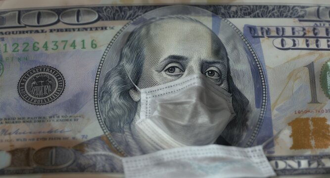 Close-up of a hundred dollar bill with a face mask on the portrait, financial crisis concept