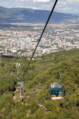 Aerial view from a cable car showing the sprawling city of Skopje, North Macedonia, nestled in a...