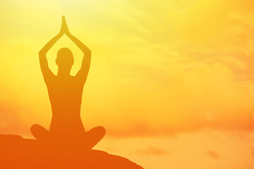 Silhouette of Person Meditating Outdoors at Sunset in Tranquil Setting
