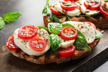 Delicious sandwiches with mozzarella cheese and tomatoes on grey table, closeup