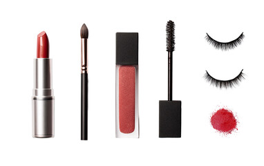 Flat lay of makeup items, including lipstick, liquid lipstick, mascara, makeup brush, and false eyelashes, in a light terracotta or rose-brown color palette