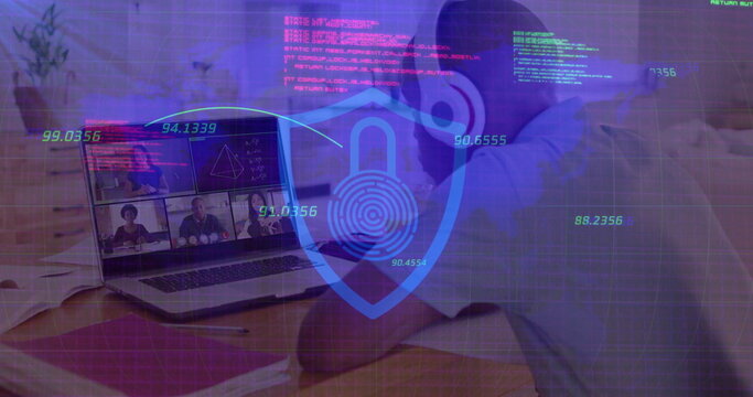 Displaying holographic security shield icon floating over desk at home, with laptop and papers