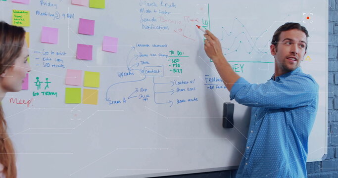 Writing lead in blue shirt updating whiteboard in conference room with sticky notes, copy space