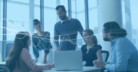 Collaborating five professionals analyzing dotted-line charts in modern meeting room, with laptop