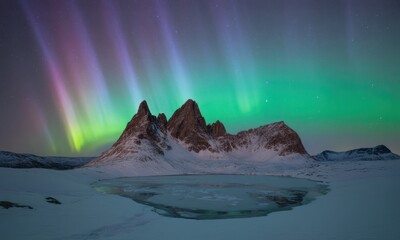 Naklejka premium Aurora borealis illuminates jagged peaks over frozen lake