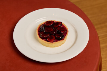 A beautifully presented and delicious Cherry Tart displayed on a lovely white plate