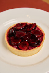 Indulge in a Delicious Cherry Tart with a Glaze on a Beautiful White Plate, perfect for any occasion