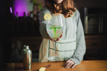 Female bartender making a mojito cocktail.