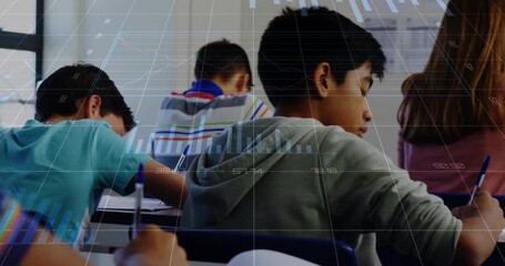 Student wearing hoodie writing lifting head on audio cue glancing camera floating charts classroom