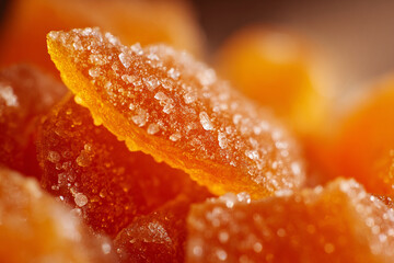 Bright orange candy pieces glistening with sugar in close-up view from a confectionery display