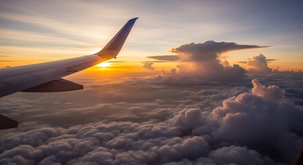 Fototapeta premium Airplane wing flies over ocean of clouds during golden hour sunset with warm sunlight illuminating dramatic storm clouds