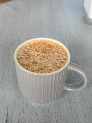 A cup of popular drink in Malaysia called Teh Tarik. It is a sweet drink made from tea with milk. 