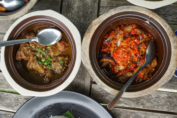 A flavorful assortment of side dishes served with rice, including spicy red snapper in tamarind gravy, crispy fried chicken, stir-fried chili eggplant, rich beef rendang, and seasoned vegetable salad.