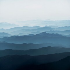 Fototapeta premium Misty mountain range layers create a cool blue ethereal scenery impression from above