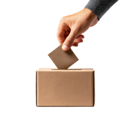 A hand inserts a ballot into a cardboard box