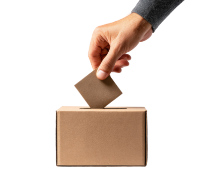 A hand inserts a ballot into a cardboard box
