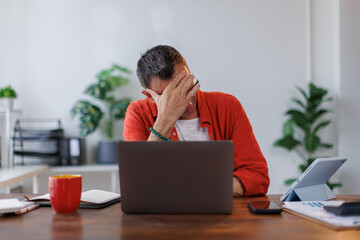 Worried mature professional business man reading bad news in document at work. Tired upset busy 50s...