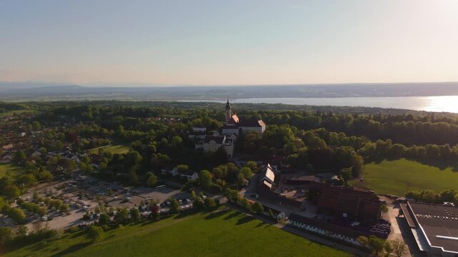 Aerial drone video of Kloster Andechs and pilgrimage church on Holy Mountain by Lake Ammersee, Bavaria, Germany. Scenic sunset view of monastery, nature, and rural landscape near Munich