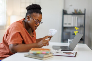 Unhappy woman feeling stressed calculating monthly expenses at home, facing financial problems or...