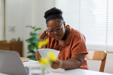 Unhappy woman feeling stressed calculating monthly expenses at home, facing financial problems or...