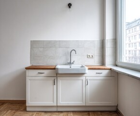 Fototapeta premium A simple, modern kitchen corner, showcasing minimalist white cabinetry, a light-gray tiled backsplash, and a neutral color palette.